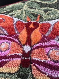 a crocheted butterfly is laying on the ground