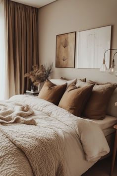 a large bed sitting in a bedroom next to a window covered in blankets and pillows