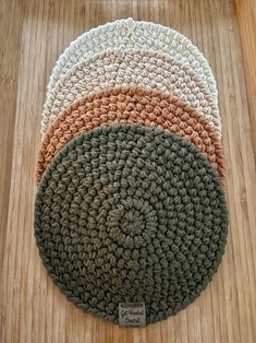 three round crocheted rugs sitting on top of a wooden floor