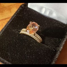 an orange and white diamond ring in a black box