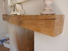 an old fashioned telephone sitting on top of a wooden shelf next to a wall mounted clock