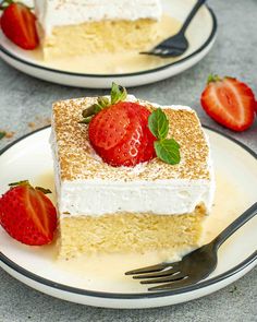 two plates with slices of cake and strawberries on them