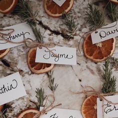 orange slices tied with twine and labeled with nametags on marble table top