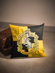 a harry potter pillow sitting next to a suitcase