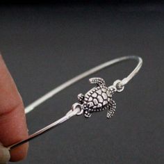 Sea Turtle Bracelet, Sea Turtle Bangle, Silver Turtle Jewelry Sea turtle charm bracelet in silver tone. Cute little turtle charm is transformed into a sea turtle bangle bracelet.  Sea Turtle Charm: 20 mm x 12 mm Bracelet Band: Thick Silver Filled Crystal Birthstone: 6 mm (optional) This sea turtle charm bangle bracelet is closed and slips over your hand.  It comes in three standard sizes: Small: 8'' circumference/ 2 1/2'' diameter (MOST COMMON) Medium: 8.5'' circumference/ 2 3/4'' diameter Large Silver Dainty Bracelets For Beach, Dainty Silver Bracelets For The Beach, Sea Turtle Bracelet, Turtle Jewelry, Turtle Bracelet, Bangle Silver, Jewelry Beach, Turtle Charm, Sea Animal