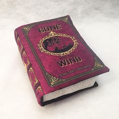 a red book sitting on top of a white table next to a black and gold cover