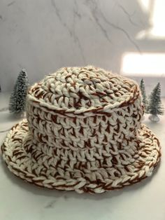 The S'mores Chunky Bucket Hat is a handmade crochet bucket hat made with two different color yarns in a one size fits all adults size. It is very soft and cozy, however it is not lined with fabric underneath so you may feel a bit of air though the brim. The neutral colors are perfect to pair with any winter outfits, offering a cozy and stylish look. Chunky Bucket Hat, African Hats, Handmade Hats, Crochet Bucket, Crochet Bucket Hat, S'mores, Handmade Hat, S Mores, Bucket Hats