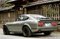 an old car parked in front of a wooden building