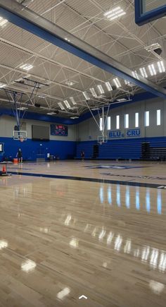 an empty gym with hard wood flooring and blue paint on the walls is shown