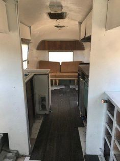 the inside of an rv with wood flooring and cabinets in it's center