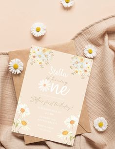 a pink and yellow birthday party with daisies on the table next to some flowers