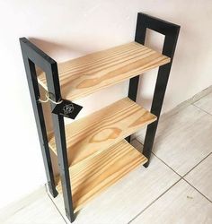 a wooden book shelf sitting on top of a tiled floor