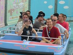 a group of people riding on the back of a roller coaster at an amusement park