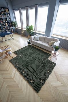 a living room filled with furniture and a large rug on top of a hard wood floor