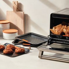 there are cookies and muffins being cooked in an electric oven on the counter