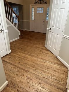 an empty room with wooden floors and white doors on either side of the door is a set of stairs