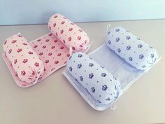 three baby pillows sitting on top of a table next to an empty bag and pillow