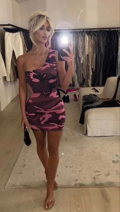 a woman taking a selfie in front of a mirror wearing a pink camo dress