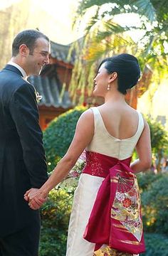 a man and woman in formal wear holding hands