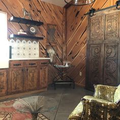 a living room filled with furniture and wooden paneling on the side of a wall