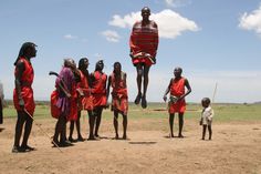 a group of people standing around each other in front of a man flying through the air