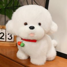 a white stuffed dog sitting on top of a wooden table next to a clock and calendar