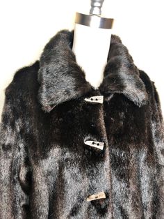 This is a faux fur, reversible jacket by Mackintosh, New England. The fur is soft and cozy and has the look of mink. The buttons look like horn and add a fun vintage flair. The reverse side is brown water resistant fabric, with fur trim. There is some creasing in the reverse fabric (see picture 7) which does not effect wearability. This is a stylish and very practical jacket, ready for whatever Mother Nature has in store. Size tag L. Check measurements carefully. Measurements taken with jacket l Classic Faux Fur Coat With Fur Trim, Classic Mink Faux Fur Coat, Classic Mink-colored Faux Fur Coat, Classic Mink Color Faux Fur Coat, Classic Fur Coat With Faux Fur Lining For Fall, Classic Fall Fur Coat With Faux Fur Lining, Fall Mink Color Fur Coat With Faux Fur Trim, Classic Mink Outerwear With Faux Fur Lining, Winter Faux Fur Coat With Button Closure