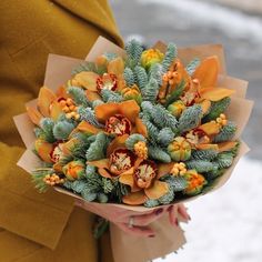 a woman holding a bouquet of flowers in her hands on a snowy day with snow