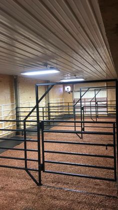 an empty room with several stalls in the center and some stairs to the other side