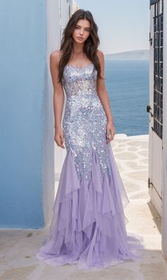 In soft lilac purple, this long sequin mermaid prom dress is a total feast for the eyes. With shimmering sequins from the sheer corset-style bodice to the hem, this long purple ruffled mermaid formal dress is a dazzling sight to behold whether you're attending prom, a pageant, or another black-tie event. The sheer-bodice long sequin evening gown has thin shoulder straps that lace-up over the cut-out back, while the hip-skimming long skirt has vertical ruffles that flow to the floor in glamorous Lavender Sequin Dress, Sparkly Purple Prom Dress, Sequin Mermaid Prom Dress, Purple Prom Dresses, Pagent Dresses, Hoco 2024, Lavender Prom Dresses, Fantasy Clothes, Gown For Prom