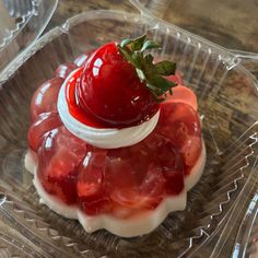 there is a strawberry on top of some jelly in a glass dish with strawberries