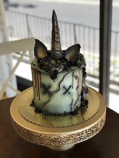 a decorated cake sitting on top of a wooden table next to a glass window in a room