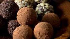 chocolate truffles are stacked on top of each other in a wooden bowl, ready to be eaten