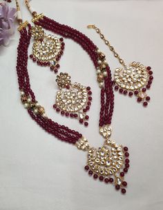 Ruby Red Kundan Necklace Set With Earrings And Tikka, Indian Jewelry, Bollywood Jewelry, Sabyasachi Inspired Jewelry, Bridal Necklace Set * Necklace Length: 24 inches (comes with adjustable sarafa/dori/cord) * Earrings Length: 3 inches approx * Maang Tikka: Freesize * Material: Copper, Kundan * Package: Necklace, Earrings and Maang Tikka STYLE TIP: The Look Is Stunning And Perfectly Suitable For All Kinds Of Dressy Occasions. Wear with an ethnic outfit for any occasion. This traditional set can Red Chandbali Bridal Necklace With Latkans, Red Kundan Jewelry With Round Beads, Red Bollywood Bridal Necklace With Latkans, Red Bridal Necklace With Latkans For Diwali, Red Bridal Necklace With Latkans For Celebration, Ceremonial Red Jewelry With Cutdana, Red Kundan Necklace With Intricate Design For Ceremonial Occasions, Red Kundan Bridal Necklace With Latkans, Ceremonial Red Kundan Necklace With Intricate Design