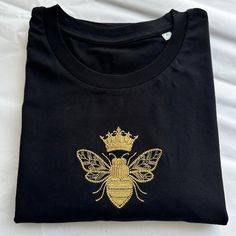 Embroidered Queen Bee T-shirt using a lovely soft t-shirt! This little design is embroidered by me, it's a super cute basic Tee and would make a great gift for someone special or little treat to yourself! The t-shirts are unisex so have a relaxed fit for ladies. *Eco-Friendly tee from a sustainable and ethical wholesaler* I am a size 12/14 and like to wear a large. Each item is made to order so if you need further measurements please send me a message. Bee T Shirt, Embroidery Tshirt, Tea Shirt, Little Designs, Shirt Embroidery, T Shirt Photo, Bee Design, Embroidery Ideas, Queen Bee