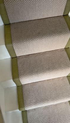 the carpeted stairs are lined with green and white fabric, along with two matching rugs