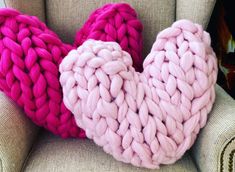 two knitted hearts sitting on top of a chair