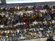 many padlocks are attached to the bridge and have been secured together with locks