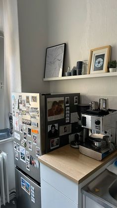 a coffee maker sitting on top of a counter next to a refrigerator freezer covered in magnets