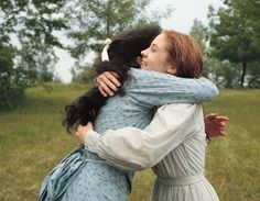 two women hugging each other in a field