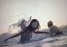 two people in the water with their arms outstretched