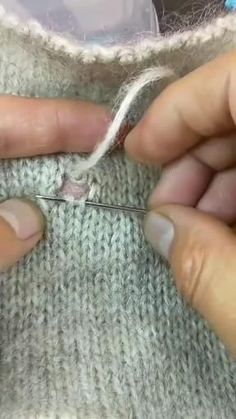 someone is working with scissors to sew the ends of a piece of fabric that has been stitched together