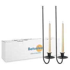 two candles sitting next to each other in front of a box