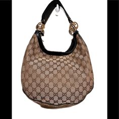 Brown And Tan Gucci Hobo Handbag With A Black Strap And Gold And Silver Hardware. Bag Is In Excellent Condition, No Tears Or Rips On The Outside Or The Inside. Bag Is Very Clean Inside And Out No Stains. Designer Hobo Bag With Detachable Handle, Designer Hobo Bag With Gold-tone Hardware And Double Handle, Gold Bags With Leather Handles For Formal Occasions, Formal Gold Bag With Leather Handles, Formal Gold Bags With Leather Handles, Gold Monogram Canvas Shoulder Bag For Shopping, Luxury Gold Hobo Bag, Luxury Handheld Hobo Bag, Designer Hobo Bag With Leather Handles For Formal Occasions