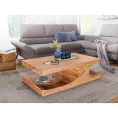 a living room filled with furniture and a wooden table in front of a gray couch