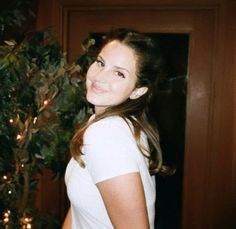 a woman standing in front of a christmas tree