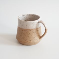 a white and brown mug sitting on top of a table