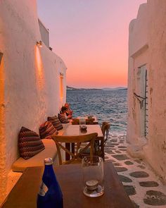 an outdoor dining area overlooking the ocean at dusk