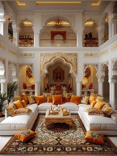 a living room filled with white couches and orange pillows on top of a rug