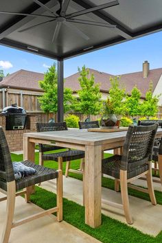 an outdoor dining table and chairs on the grass